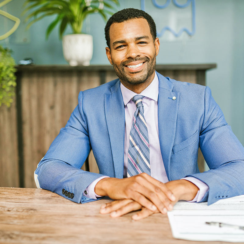 Man Sitting at Table and Smiling Man Sitting at Table and Smiling